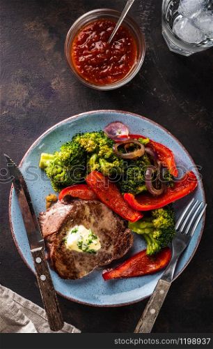 Grilled Beef steak with garlic butter and vegetables. Meat with grilled bell pepper, broccoli and onions.