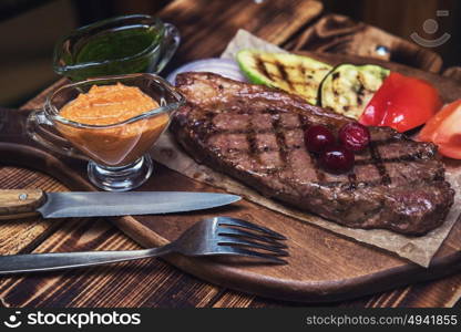 grilled beef steak with sauce and vegetables. grilled beef steak