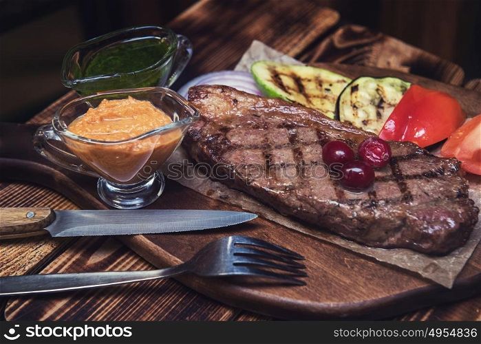 grilled beef steak with sauce and vegetables. grilled beef steak