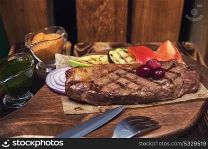 grilled beef steak with sauce and vegetables. grilled beef steak