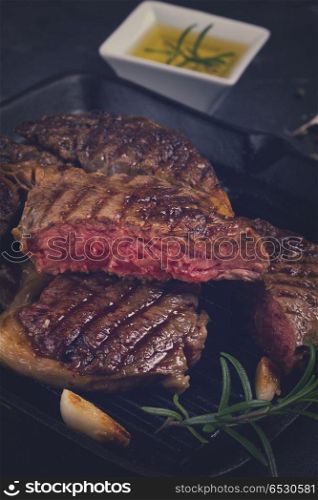 Grilled beef steak with spices on dark background, retro toned. Grilled beef steak. Grilled beef steak
