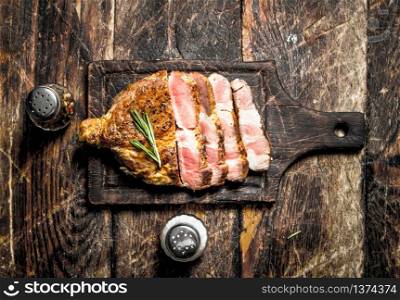 Grilled beef steak with spices. On wooden background.. Grilled beef steak with spices.