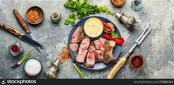 Grilled beef steak with spicy on a stone background. Beef steak medium grilled
