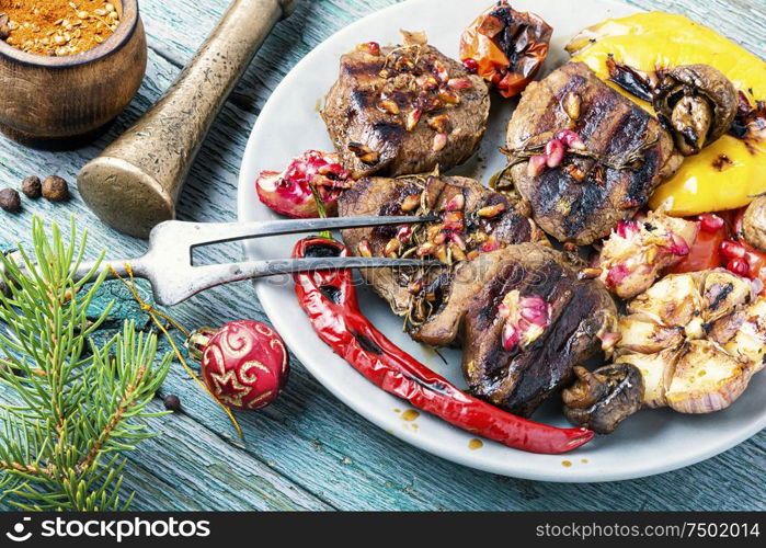 Grilled beef with vegetables to the Christmas table.Veal in pomegranate sauce.Christmas dinner. Christmas roast meat