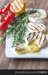 Grilled Camembert cheese with cherry tomatoes and rosemary