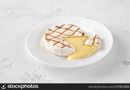 Grilled Camembert on the white plate: cross section