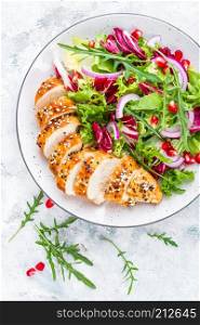 Grilled chicken breast, fillet and fresh vegetable leafy salad with arugula and pomegranate on plate. Grilled chicken breast, fillet and fresh vegetable leafy salad with arugula and pomegranate
