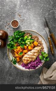 Grilled chicken breast with buckwheat, roasted butternut squash, broccoli, fresh greens and red cabbage. Healthy food, lunch menu, top view