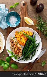 Grilled chicken breast with green beans and butternut squash, top view