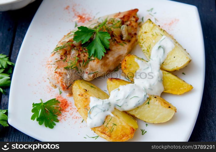 grilled chicken breast with roasted potatoes on white plate