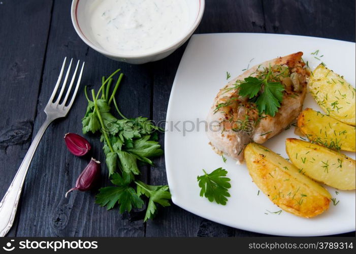 grilled chicken breast with roasted potatoes on white plate