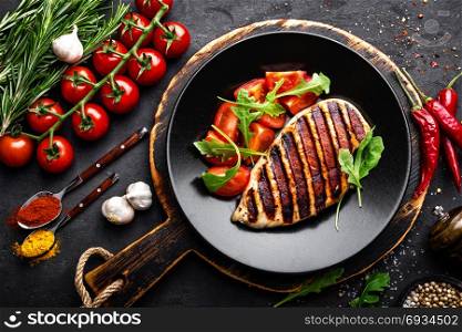 Grilled chicken fillet on black background. Top view. Grilled chicken fillet on black background, top view
