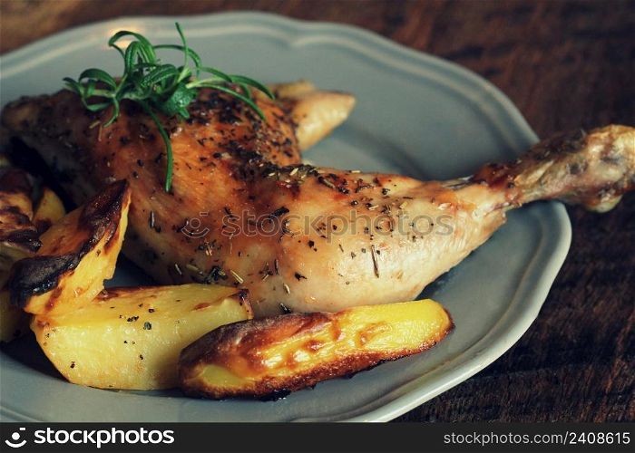 Grilled chicken leg, quarter with potato for garnish. Top view. Wooden background.. Grilled chicken leg, quarter with potato for garnish. Top view. Wooden background