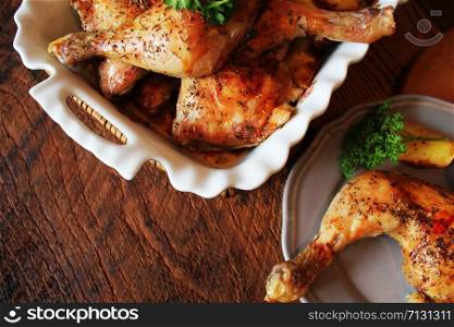 Grilled chicken legs c with potato for garnish. Top view. Wooden background.. Grilled chicken leg with potato for garnish. Top view. Wooden background.