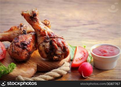 Grilled chicken legs on cutting board.Rustic dinner background.. Grilled chicken legs on cutting board.Rustic dinner background