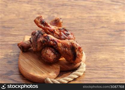 Grilled chicken legs on cutting board. Rustic dinner background.. Grilled chicken legs on cutting board. Rustic dinner background