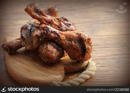 Grilled chicken legs on cutting board. Wooden rustic background. Vintage photo.. Grilled chicken legs on cutting board. Wooden background. Vintage photo.