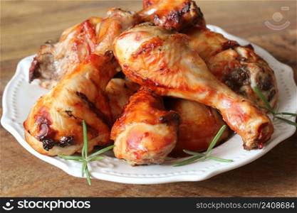 Grilled chicken legs on white plate .Rustic dinner background