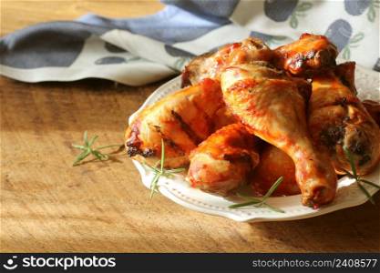 Grilled chicken legs on white plate .Rustic dinner background.. Grilled chicken legs on white plate .Rustic dinner background