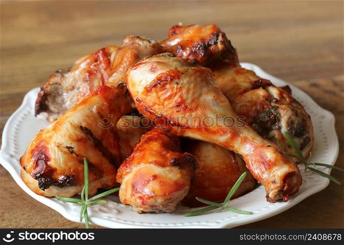 Grilled chicken legs on white plate .Rustic dinner background .. Grilled chicken legs on white plate .Rustic dinner background