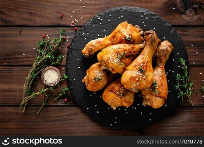 Grilled chicken legs on wooden background. Top view