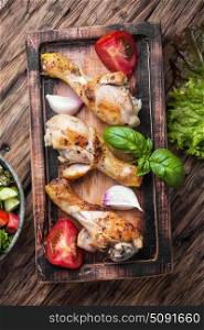 Grilled chicken legs. Roasted chicken legs on a stylish kitchen board