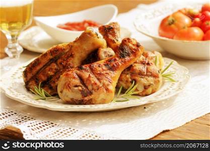 Grilled chicken legs with rosemary on table. Dinner background.. Grilled chicken legs with rosemary on table