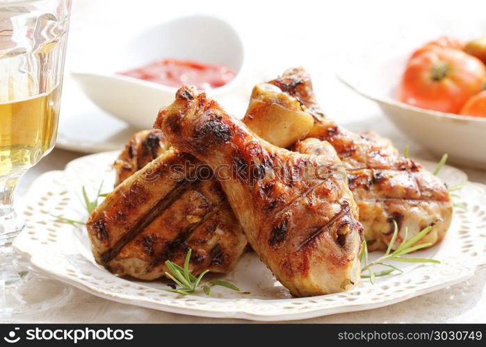 Grilled chicken legs with rosemary on table. Grilled chicken legs with rosemary on table. Dinner background.