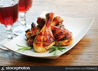 Grilled chicken legs with rosemary served on white plate. Dinner background .. Grilled chicken legs with rosemary served on white plate. Dinner background