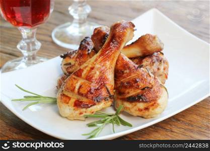 Grilled chicken legs with rosemary served on white plate. Dinner background .. Grilled chicken legs with rosemary served on white plate. Dinner background
