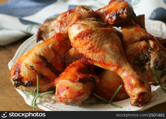 Grilled chicken legs with rosemary served on white plate. Dinner background .. Grilled chicken legs with rosemary served on white plate. Dinner background