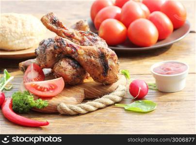 Grilled chicken legs with vegetables on cutting board.. Grilled chicken legs with herbs on cutting board. Dinner background.