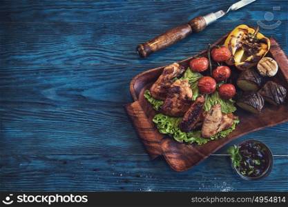 Grilled chicken meat. Grilled chicken meat with vegetable on a blue wooden background