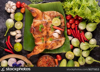 Grilled chicken on a plate with chili peppers, garlic sauce and sprinkled with pepper seeds.