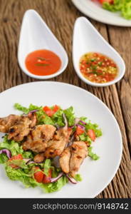 Grilled chicken on a white plate with a salad of tomatoes, carrots and chilies cut into pieces. Selective focus.