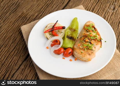 Grilled chicken on a white plate with tomatoes, salad, onion, chili and sauce.