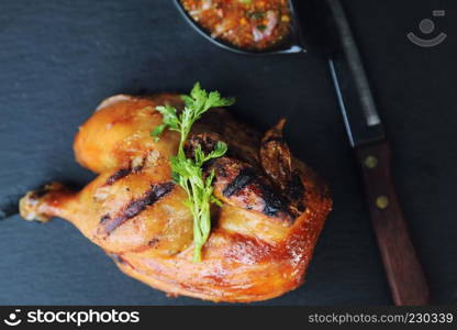 Grilled chicken on black dish wood background