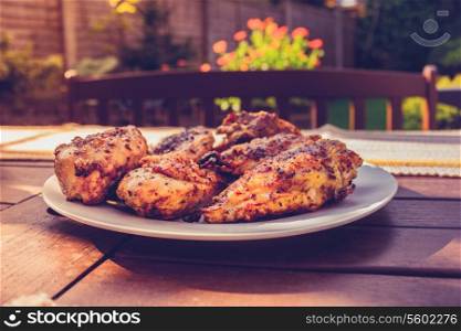 Grilled chicken pieces on a table in a garden