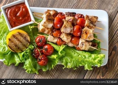 Grilled chicken skewers on the white plate