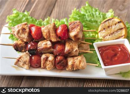 Grilled chicken skewers on the white plate