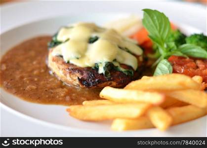 Grilled chicken steak served with chips, potatoes and vegetables