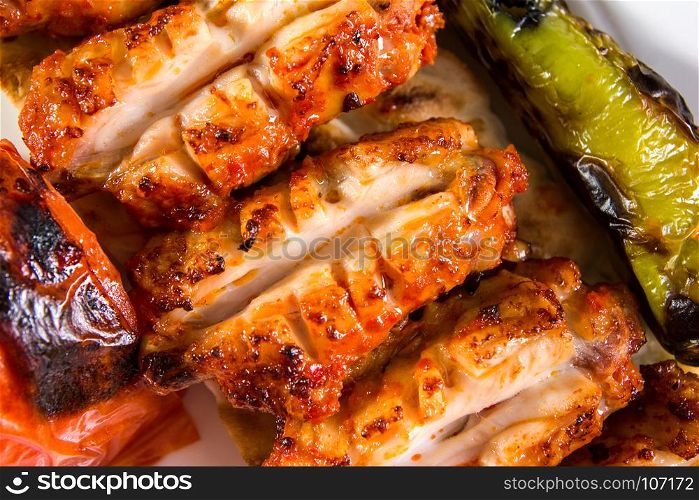 Grilled chicken wings served with pepper and tomato top view