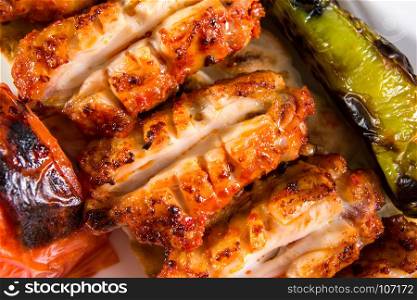 Grilled chicken wings served with pepper and tomato top view
