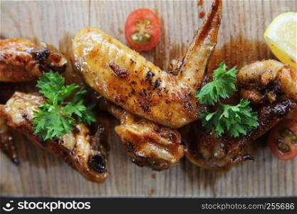 Grilled Chicken Wings with Red Spicy Sauce on wood background
