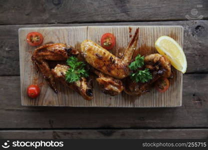 Grilled Chicken Wings with Red Spicy Sauce on wood background