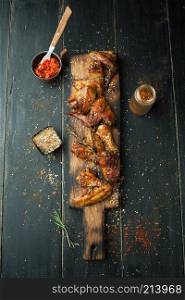 Grilled chicken wings with spices and rosemary on a wooden background