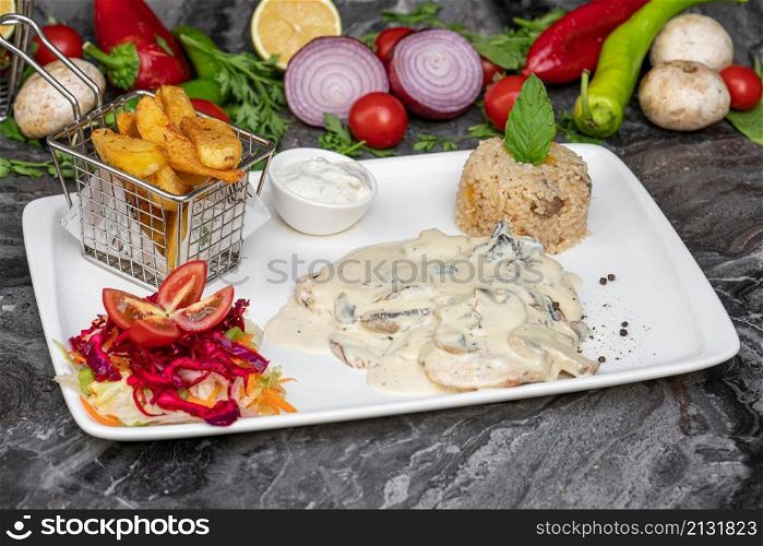 Grilled chicken with cream and mushrooms on a white porcelain plate