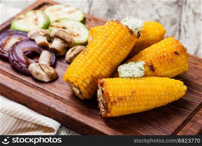 Grilled corn. Grilled corn cobs on wooden plate
