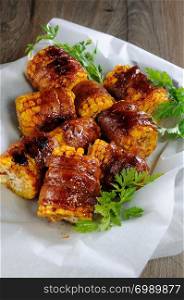 Grilled corn wrapped with bacon slices under BBQ sauce