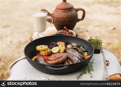 Grilled different meat sausages with vegetables and spices. Grilled sausages with vegetables